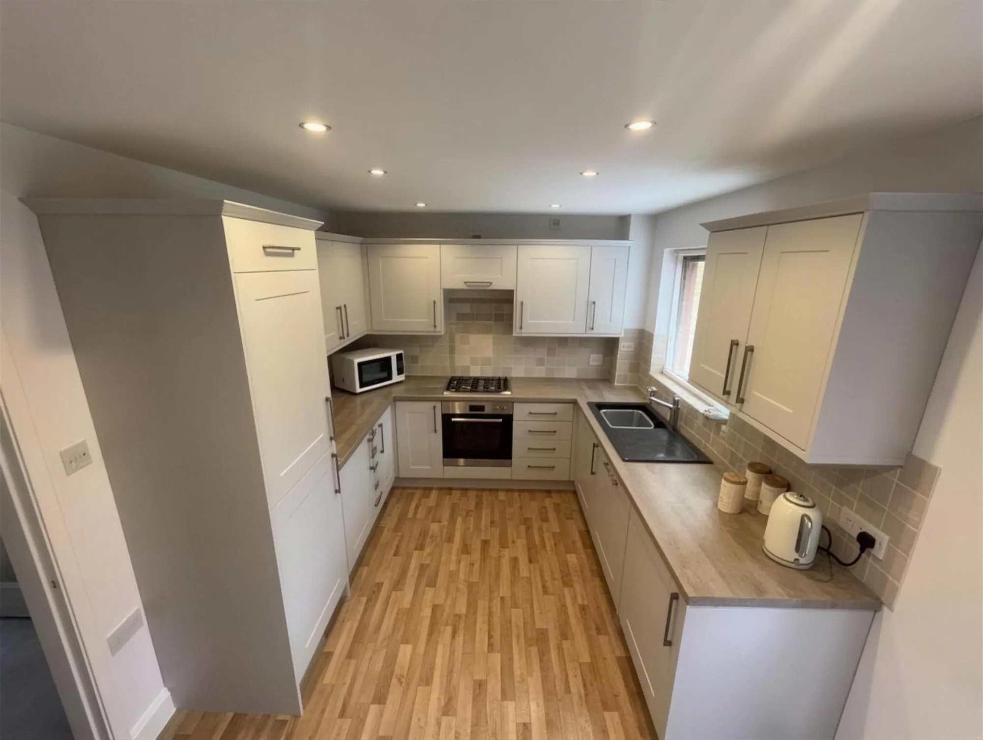 Refurbished grey shaker kitchen with laminate flooring